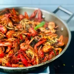 Sustainable seafood, such as the crawfish in a stainless steel skillet pictured here, are beneficial to the aquatic ecosystem and your health.