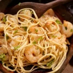A pan of shrimp pasta was cooked in a nonstick skillet, one of the essential kitchen tools.