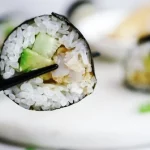 A close up photo of a shrimp tempura roll for the article titled, "Is Sushi Safe to Eat?"